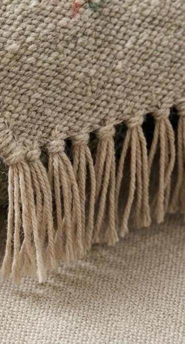 Handwoven striped wool flatweave rug in blue, rust, and sage green with ivory background and cotton fringe