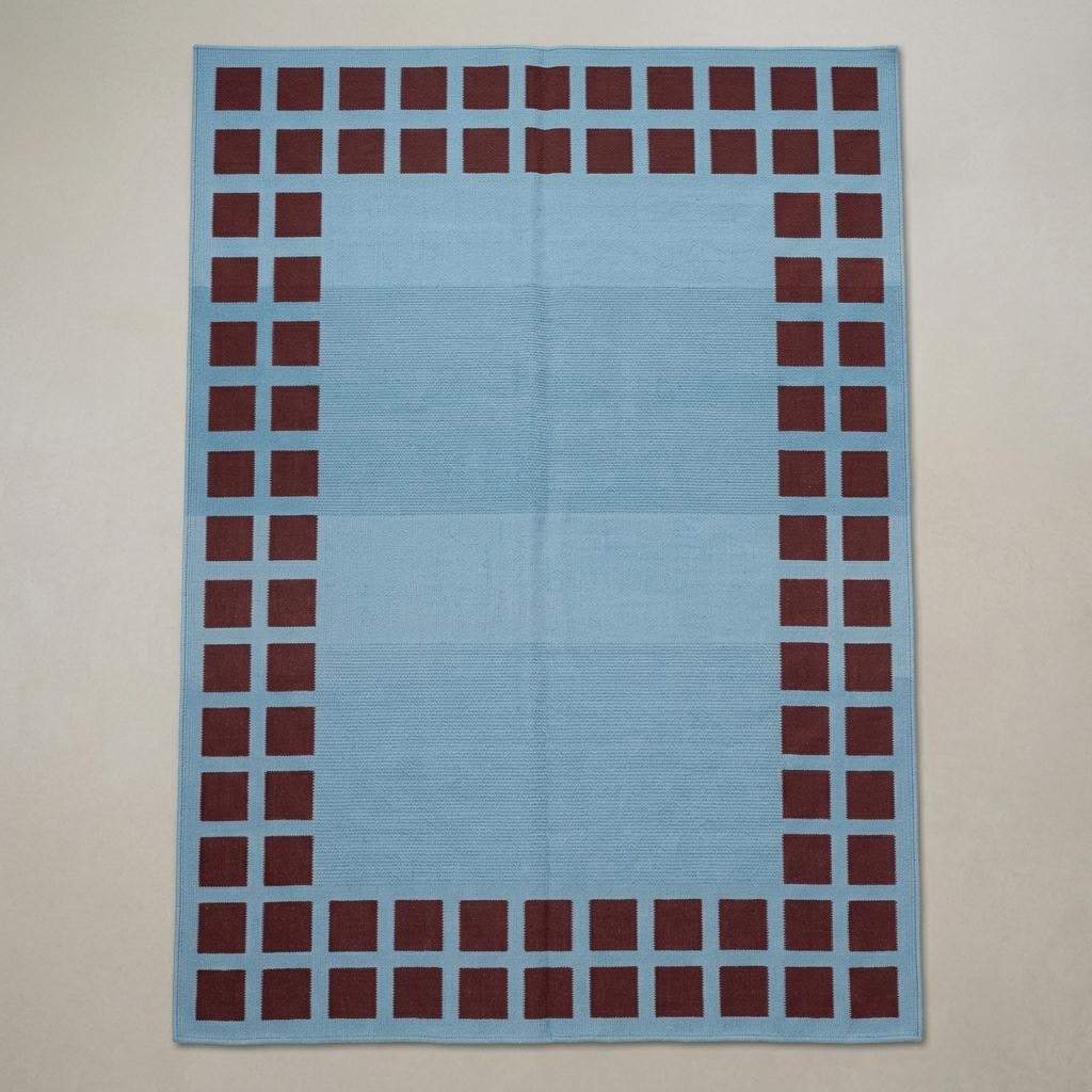 Handwoven sky blue dhurrie rug with maroon square border flatweave design