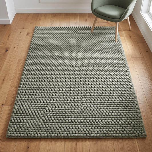 Sage green hand woven wool area rug with pebble texture and raised bobbles for living room decor