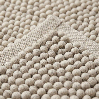 Handwoven pebble weave wool area rug in ivory and beige with textured raised loops for living room decor