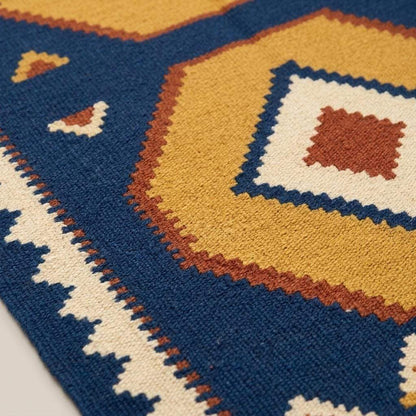 Handwoven blue kilim rug with golden hexagon medallions and ivory border in geometric tribal design