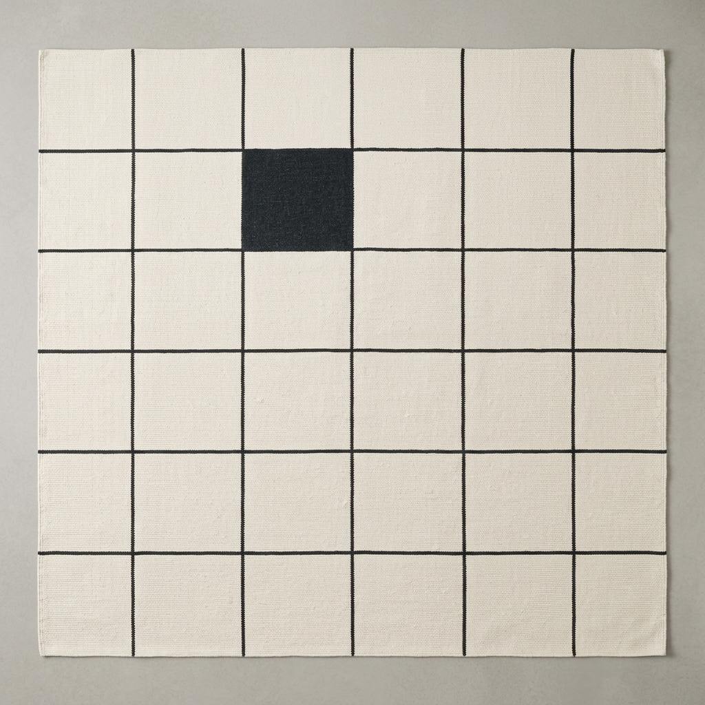 Ivory and charcoal grid wool flatweave rug with windowpane pattern in modern minimalist living room