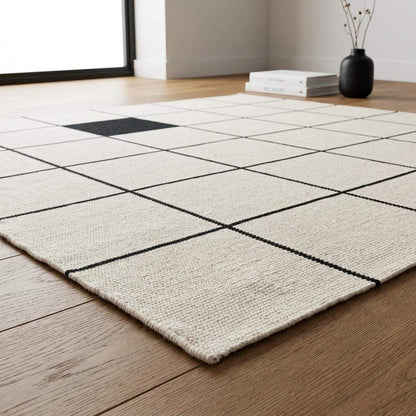 Ivory and charcoal grid flatweave wool rug with windowpane pattern in modern living room