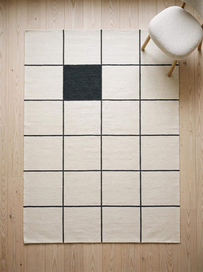 Ivory and charcoal grid flatweave wool rug with handwoven windowpane pattern for minimalist living room