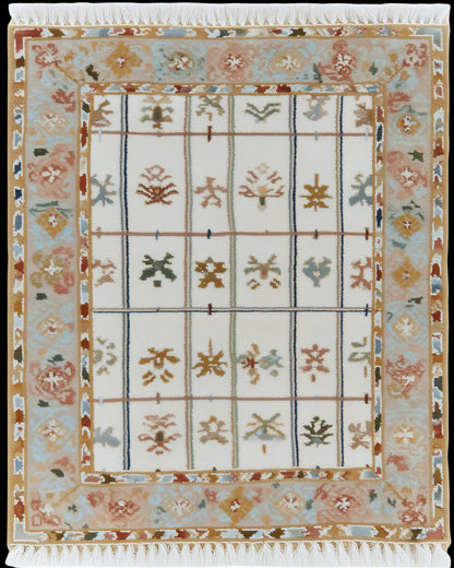 Ivory grid floral area rug with pastel floral border and fringed edges on stone floor