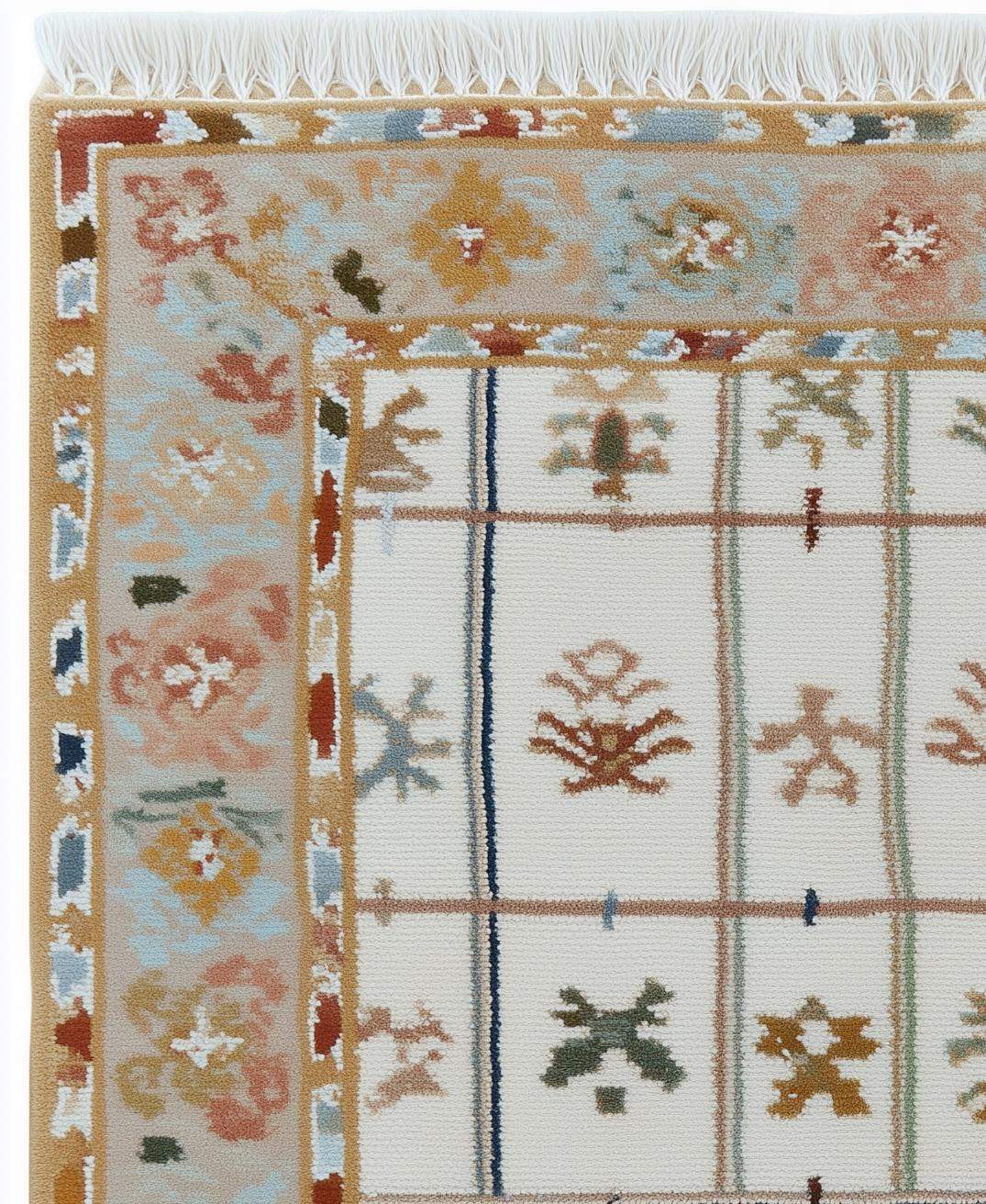 Ivory grid floral area rug with pastel border and fringed edges on stone floor