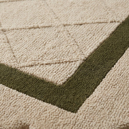 Ivory & Olive Lattice wool rug with a plush, carved ivory diamond pattern and a wide olive green border.