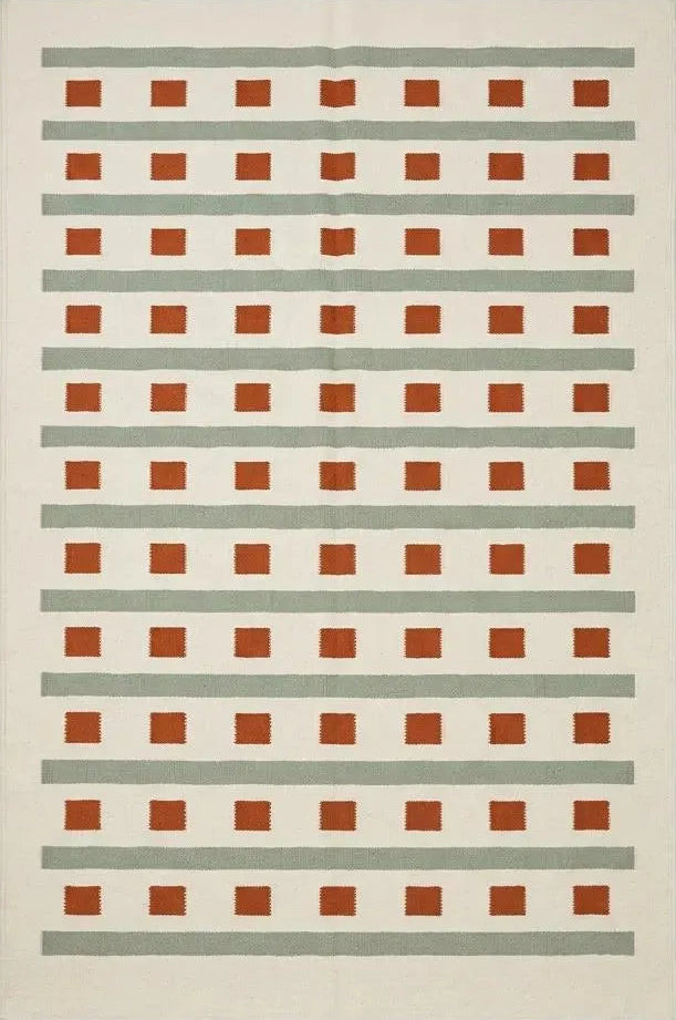 Handwoven ivory sage green flatweave dhurrie rug with terracotta stripes and squares in living room setting