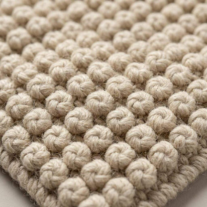 Ivory textured hand-woven wool rug with chunky bobble loop weave for neutral living room decor