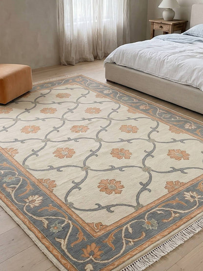 Ivory Trellis Rug in hand-knotted wool, with slate blue vine lattice, peach floral motifs and a blue floral border