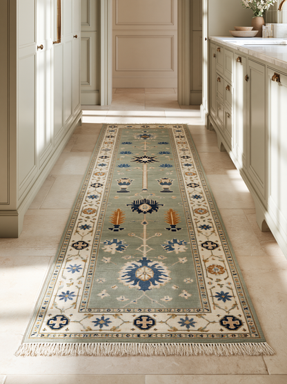 Hand Knotted Oushak Runner Rug in muted seafoam wool, with an ivory floral border, blue and amber urn motifs, and fringe.