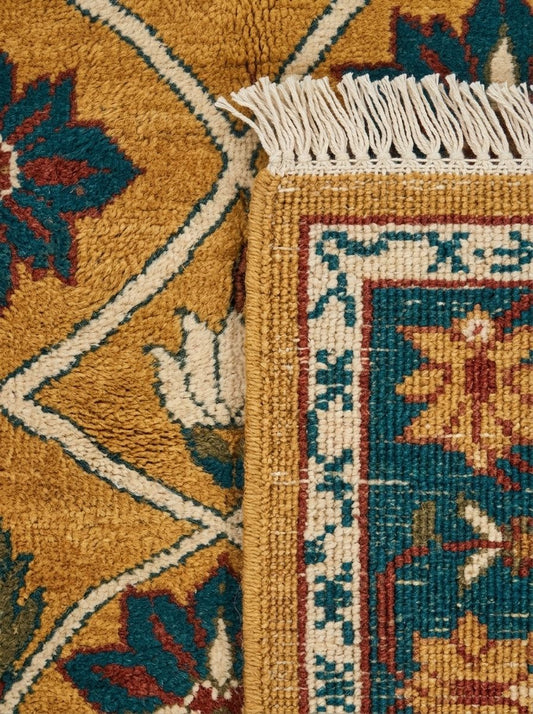Mughal Lattice Hand Knotted Wool Rug in saffron gold, teal and rust, with floral lattice motifs and cream fringe