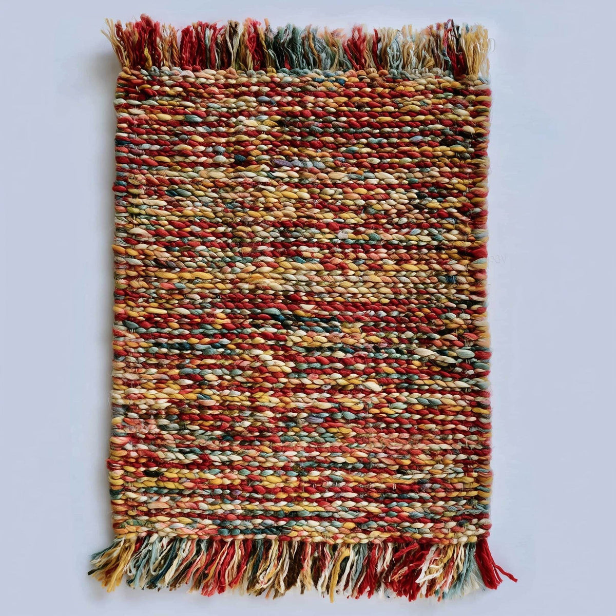 Handmade multicolor boho braided rug with vibrant red, mustard, teal, and neutral tones, adding warm, eclectic charm to home décor.