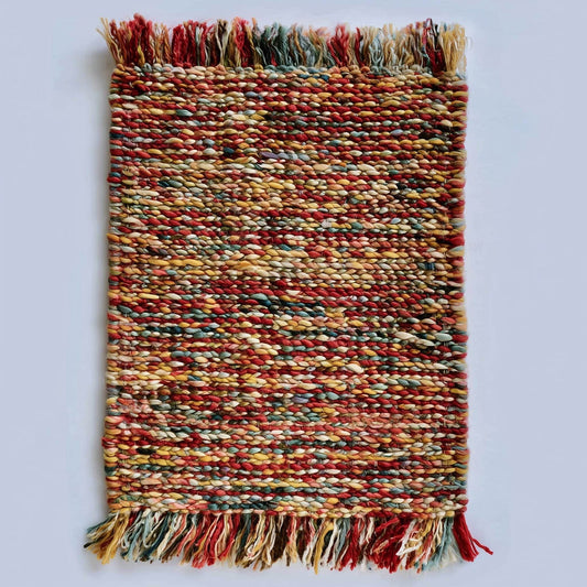 Handmade multicolor boho braided rug with vibrant red, mustard, teal, and neutral tones, adding warm, eclectic charm to home décor.