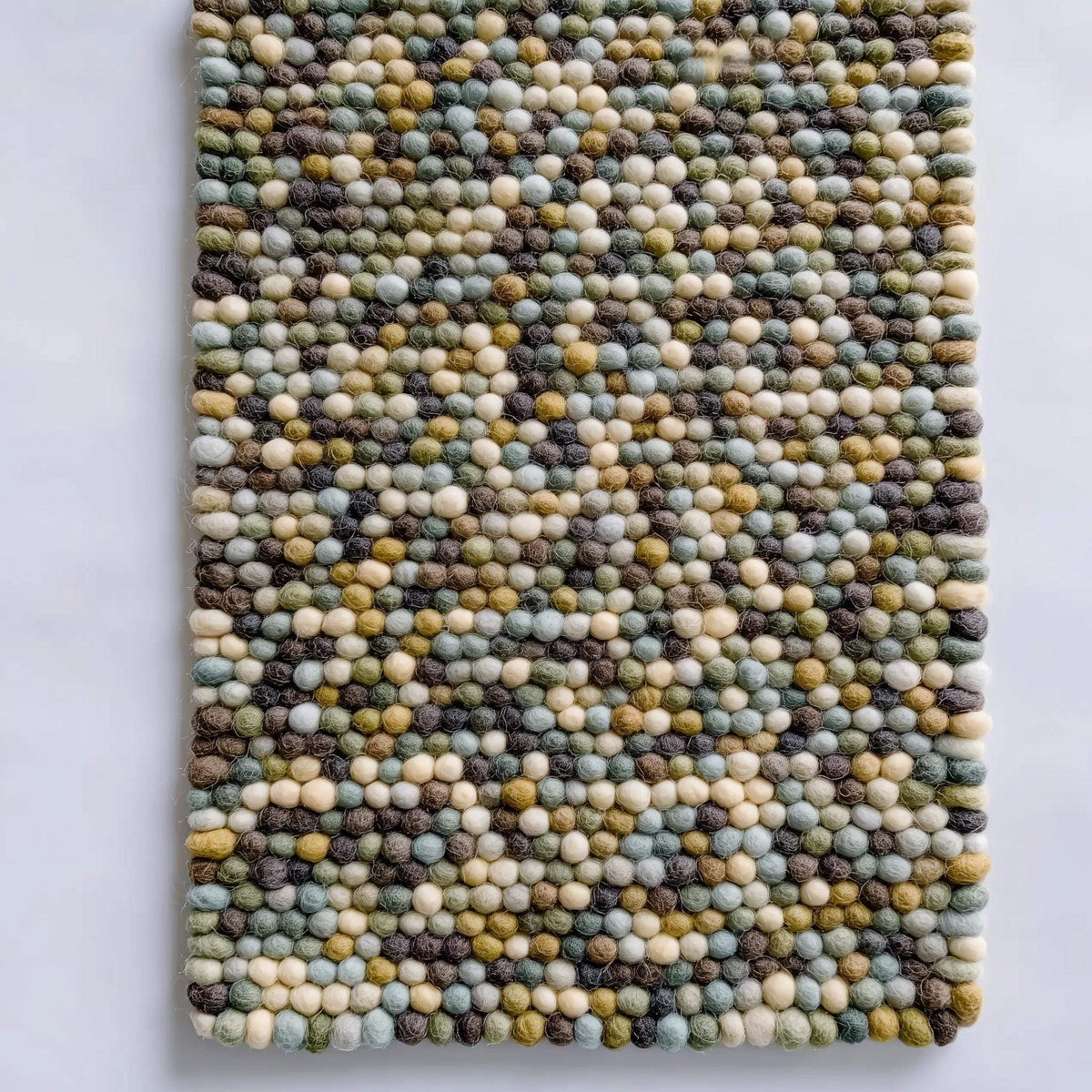 Handmade Olive & Mint Pebble Mat with textured felt wool balls in green, mint, cream, and brown tones for cozy home decor