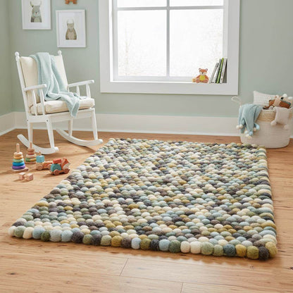 Handmade olive and mint pebble mat with wool felt balls in olive green, mint, cream, and mocha tones for textured home decor