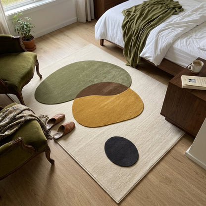 Organic Abstract Rug in ivory with rounded olive, mustard, brown and charcoal pebble shapes on a plush surface
