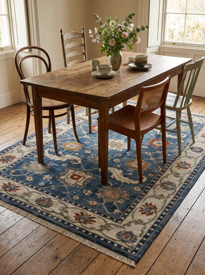 Oushak Hand Knotted Rug in blue wool, with ivory floral border, scrolling leaf motifs, and rust, sage, and gold flowers.
