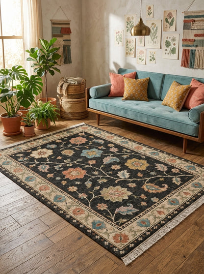 Oushak Hand Knotted Rug in charcoal black wool with colorful floral vines, ivory palmette border and fringed ends
