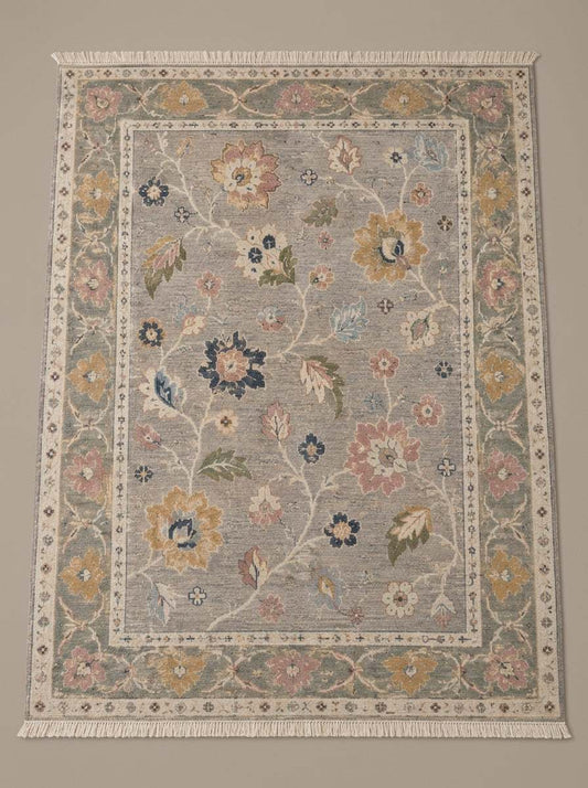Oushak Hand Knotted Rug in dove gray wool with multicolored floral vines and a sage green palmette border
