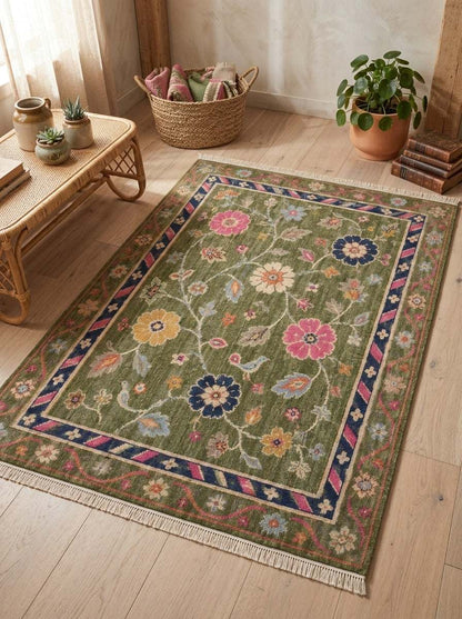 Oushak Hand Knotted Rug in olive green wool with floral vines, perched birds, pink and navy blossoms, and striped border