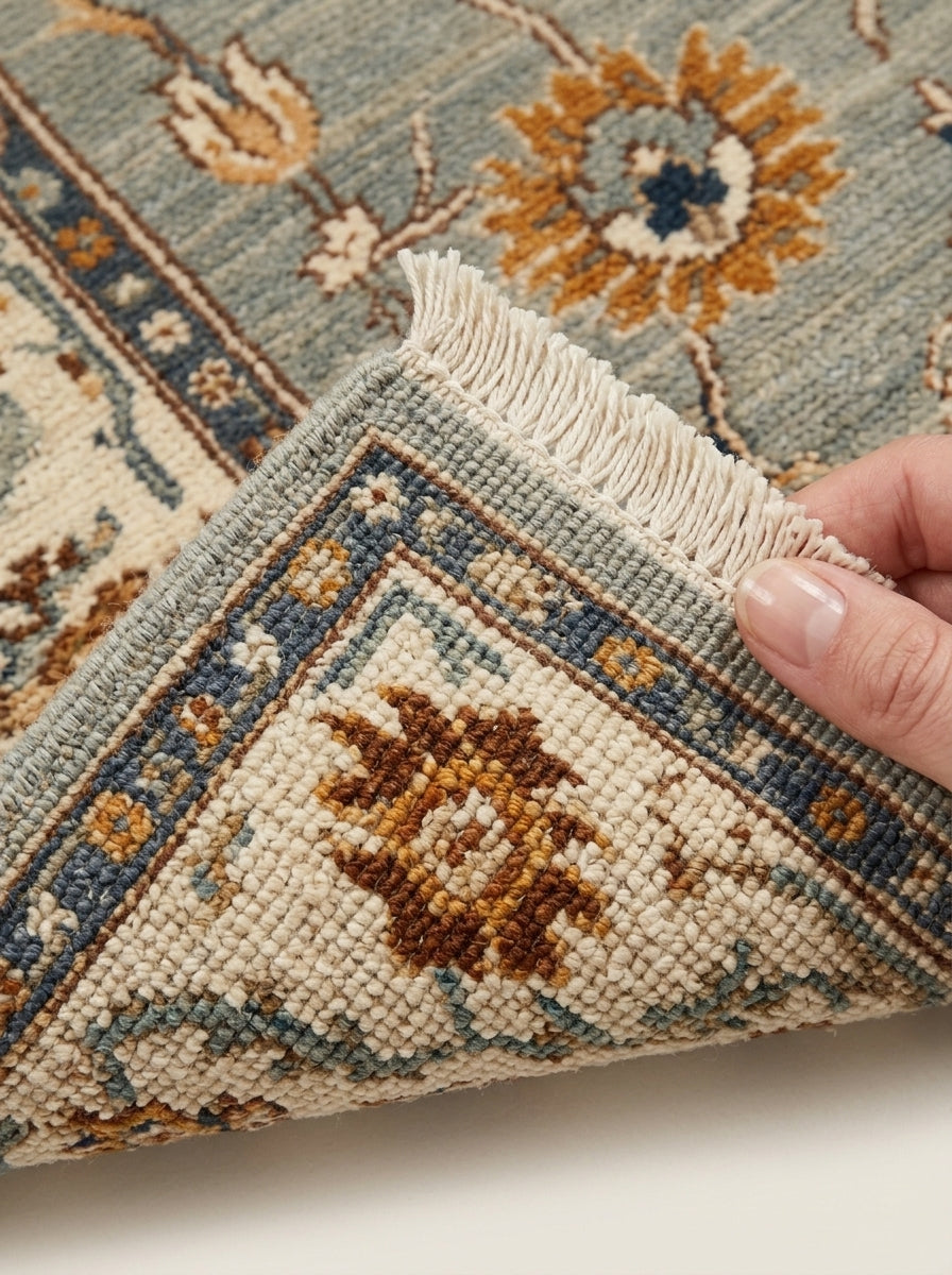 Oushak Hand Knotted Rug in sage gray wool, with ivory floral border, rust and gold blossoms, and fringe edging.