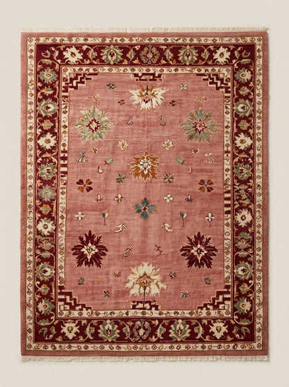 Oushak Hand Knotted Rug in dusty rose wool, with scattered floral motifs, stepped corners and a deep burgundy floral border.