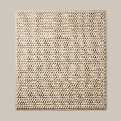 Chunky Wool Rug in cream oatmeal wool, with a thick handwoven surface of tightly spaced rounded pebble tufts and finished edges.