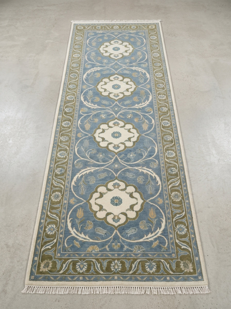 Hand Knotted Oushak Runner Rug in wool, with a muted blue field, ivory floral medallions, olive vine border and fringe.