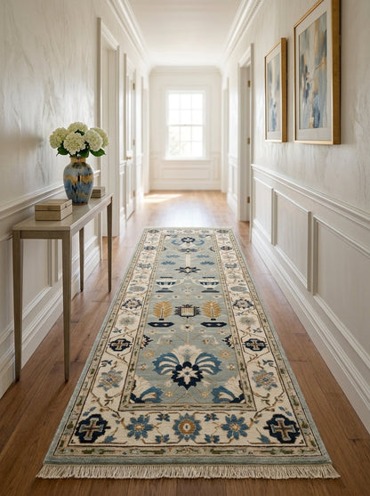 Hand Knotted Oushak Runner Rug in soft blue wool, with ivory floral border, navy and copper motifs, and fringed ends.