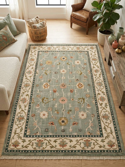 Oushak Hand Knotted Rug in muted sage wool, with scattered floral motifs, an ivory vine border, teal bands and fringe.