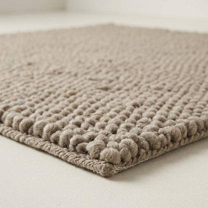 Chunky Wool Rug in taupe greige, with a thick handwoven surface of chunky rounded pebble knots and finished edges.