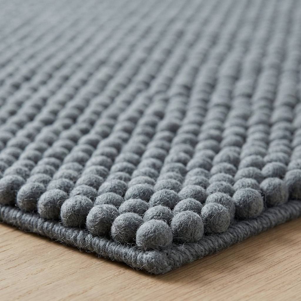 Chunky Wool Rug with a thick slate gray wool texture, featuring closely spaced rows of rounded woven pebbles.