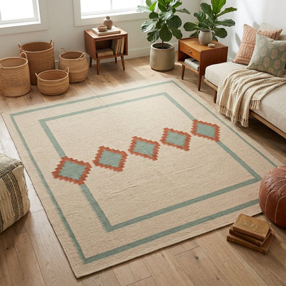 Southwestern Flatweave Wool Rug with a beige textured field, sage green double border, and terracotta stepped diamonds with sage centres.