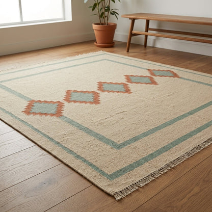 Southwestern Flatweave Wool Rug in natural beige with sage green borders, terracotta and sage stepped diamonds, and fringe edges.