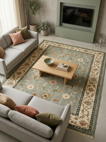 Oushak Hand Knotted Rug in muted sage wool, with scattered floral motifs, an ivory vine border, and deep teal bands.