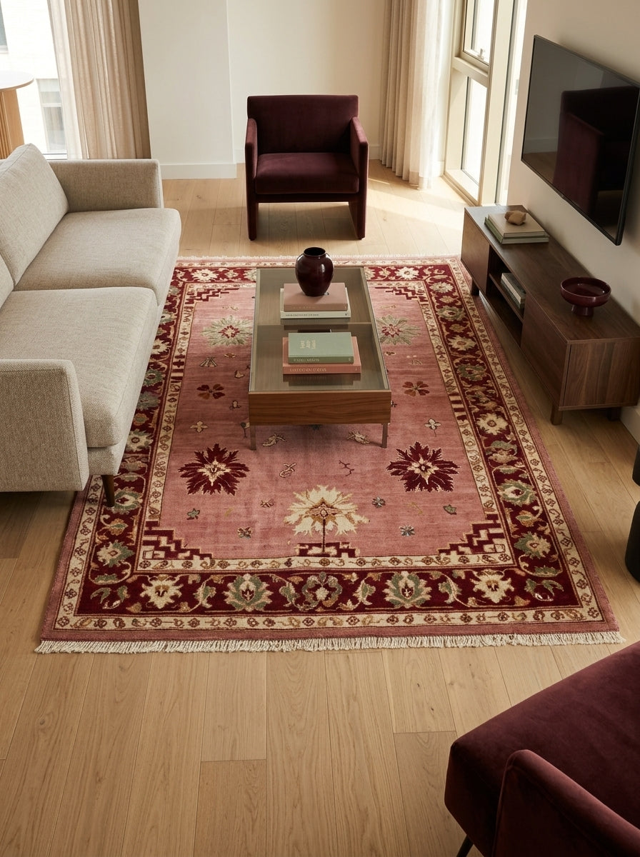 Oushak Hand Knotted Rug in dusty rose wool, with scattered floral motifs, burgundy border and ivory fringe.