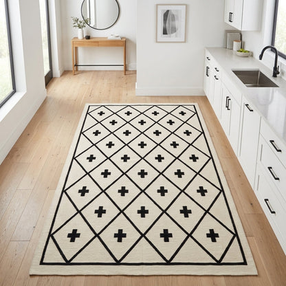 Southwestern Flatweave Wool Rug in ivory with a black diamond lattice and Swiss cross motifs, finished with a slim border.