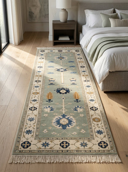 Hand Knotted Oushak Runner Rug in muted seafoam wool, with an ivory floral border, blue medallions, amber urns and fringe.