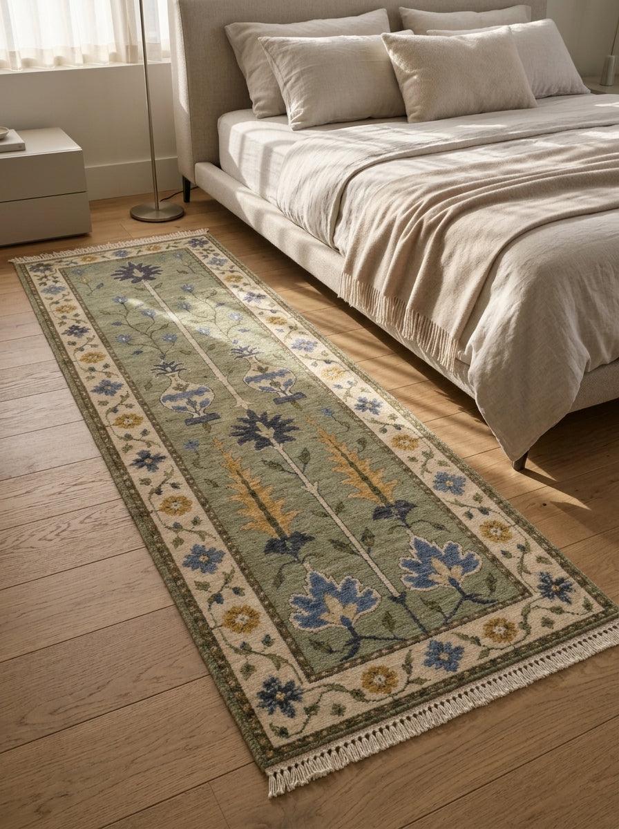 Hand Knotted Oushak Runner Rug in sage green wool, with blue and mustard floral motifs, an ivory border, and fringed ends.