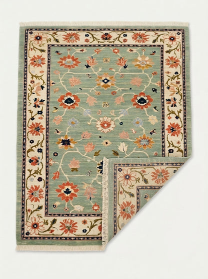 Oushak Hand Knotted Rug in mint green wool, with scattered multicolour florals, ivory vine border and fringed ends.