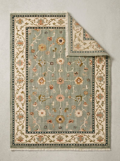Oushak Hand Knotted Rug in muted sage wool, with scattered floral vines, an ivory floral border and deep teal dotted bands.