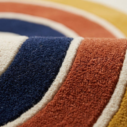 Handmade Retro Rug with tufted wool pile, featuring curved navy, rust and mustard bands separated by ivory lines.