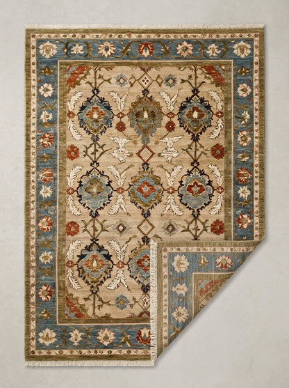 Oushak Hand Knotted Rug in camel beige wool, with a floral lattice, slate blue border and fringed ends.