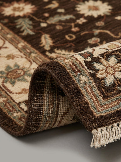 Oushak Hand Knotted Rug in espresso brown wool, with floral motifs, a beige and rust border, and fringe
