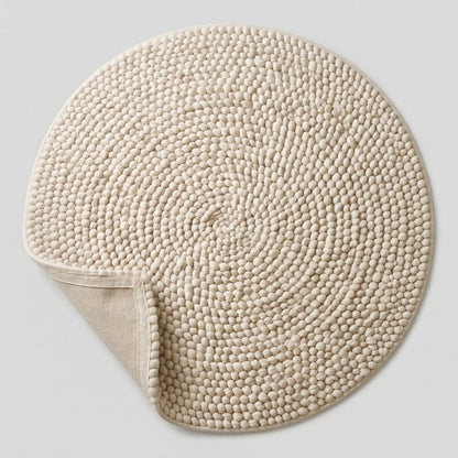 Chunky Wool Rug, round cream ivory woven textile with dense pebble-like loops and a turned-back edge revealing its plain underside