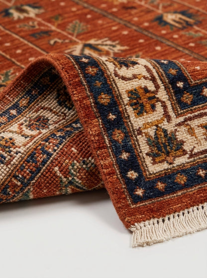 Oushak Hand Knotted Rug in rust red wool with ivory, navy and green floral motifs, bordered design and fringe ends.