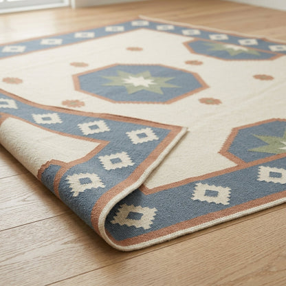Southwestern Flatweave Wool Rug in ivory with dusty blue, peach and sage star medallions and a geometric border.