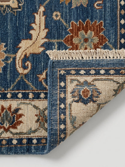 Oushak Hand Knotted Rug in blue wool with ivory floral border, rust and sage blossoms, and fringed edge