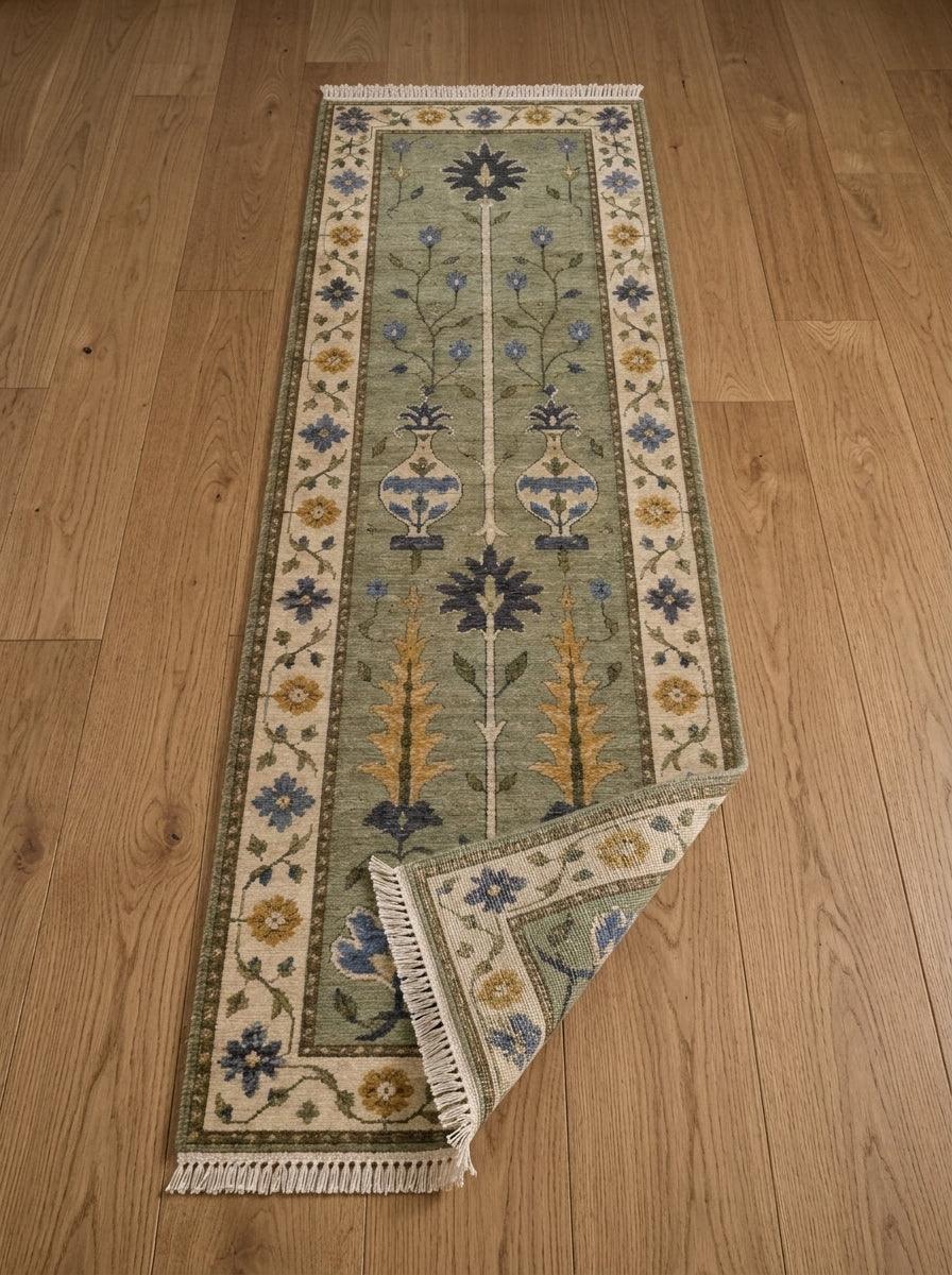 Hand Knotted Oushak Runner Rug in sage green wool, with floral vases, trees, an ivory patterned border and fringe.